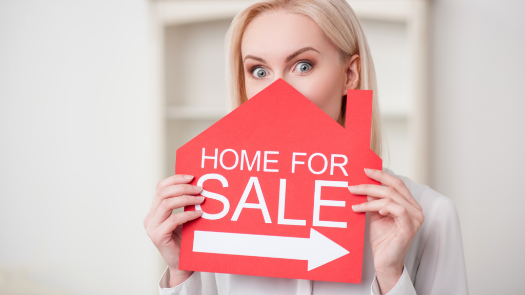 Woman holding a home for sale sign