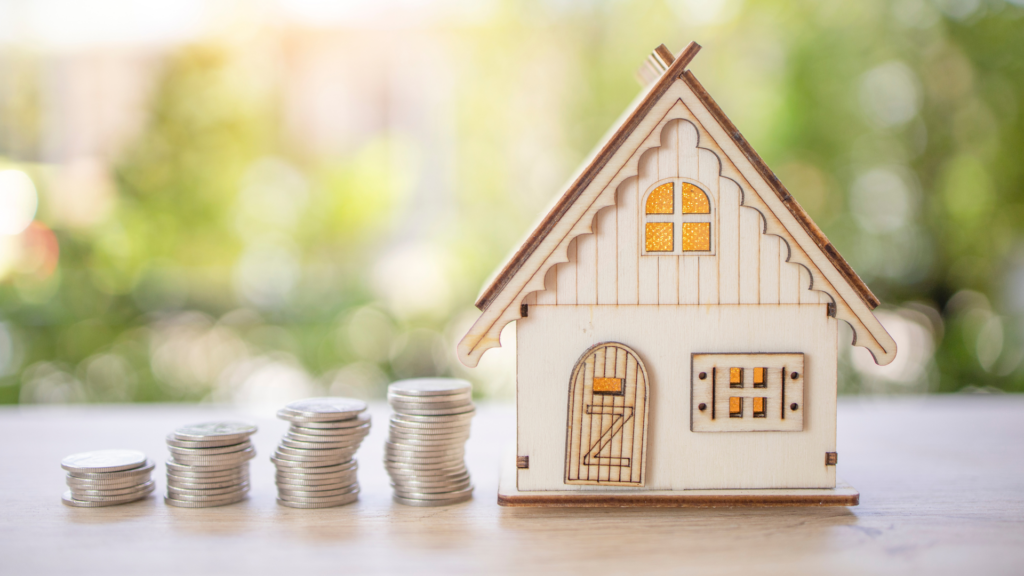 A miniature house with increasing stack of coins