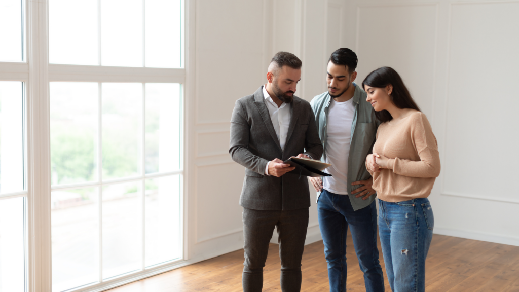 An agent explaining something on a clipboard to a couple