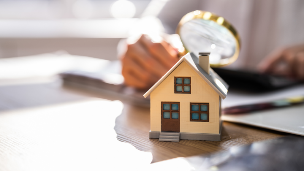 Miniature house under magnifying glass